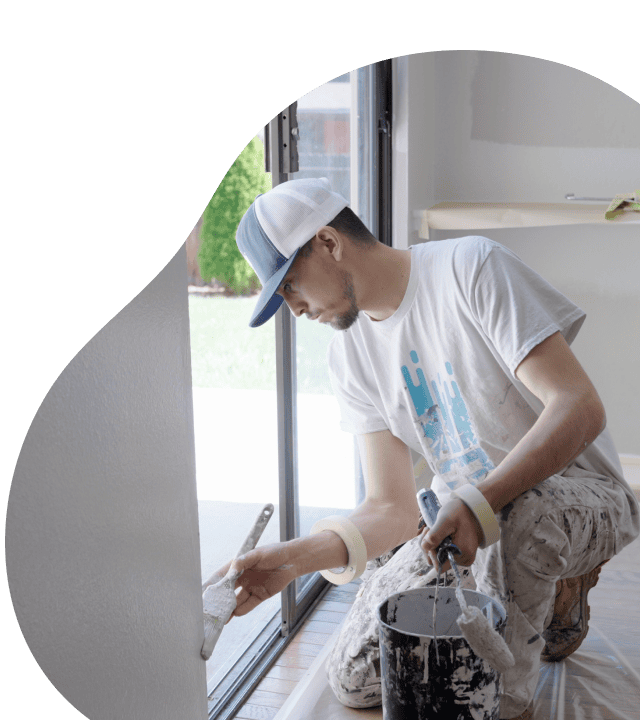 Painter applying a clean finish near a window to represent That 1 Painter's 3-year workmanship warranty
