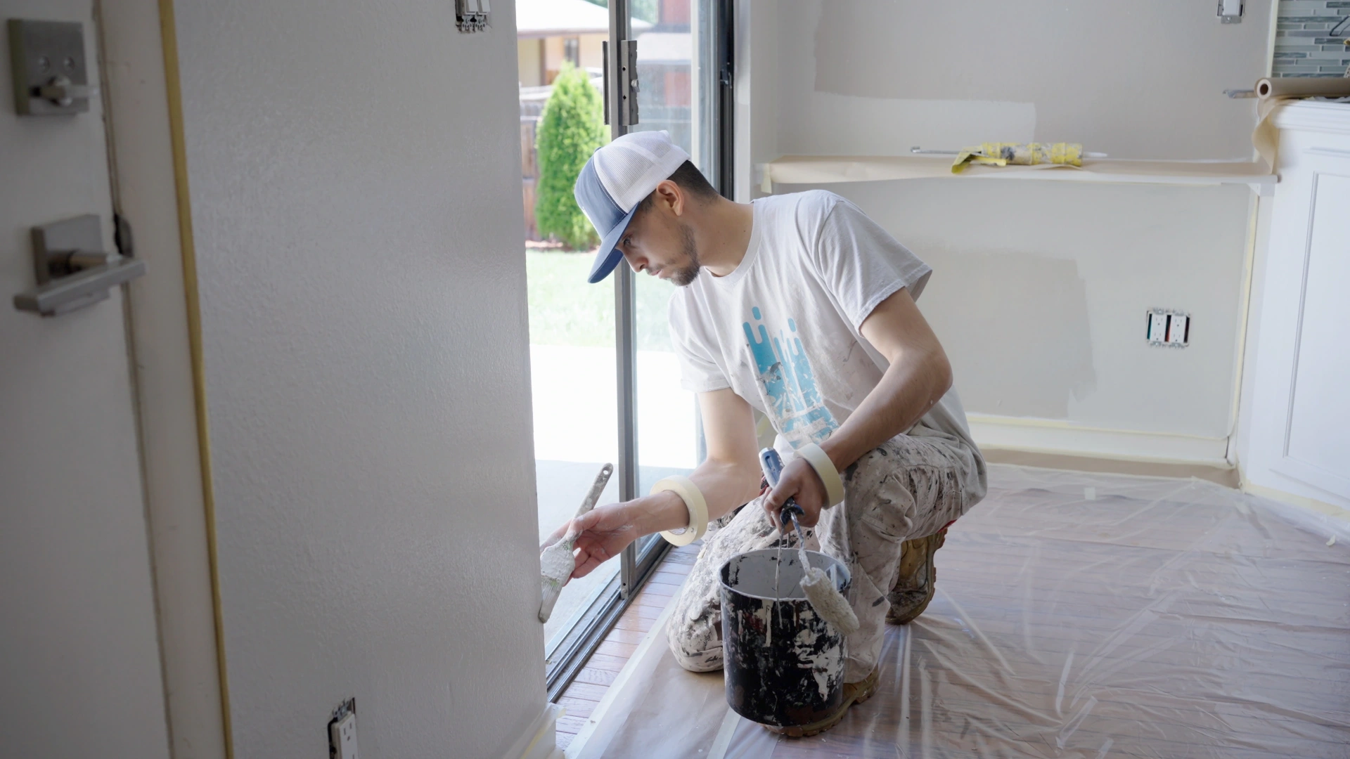 Painter applying a clean finish near a window to represent That 1 Painter's 3-year workmanship warranty